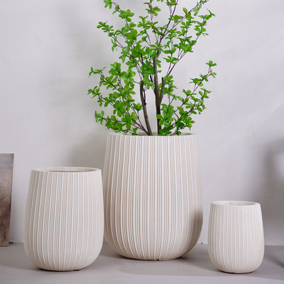 neutrale beige ronde vezelklei plantenbak met verticaal lijnenpatroon lichtgewicht duurzaam onderhoudsarm bloempot vakantie villa hotel winkelcentrum kantoordecoratie tuinlandschap project